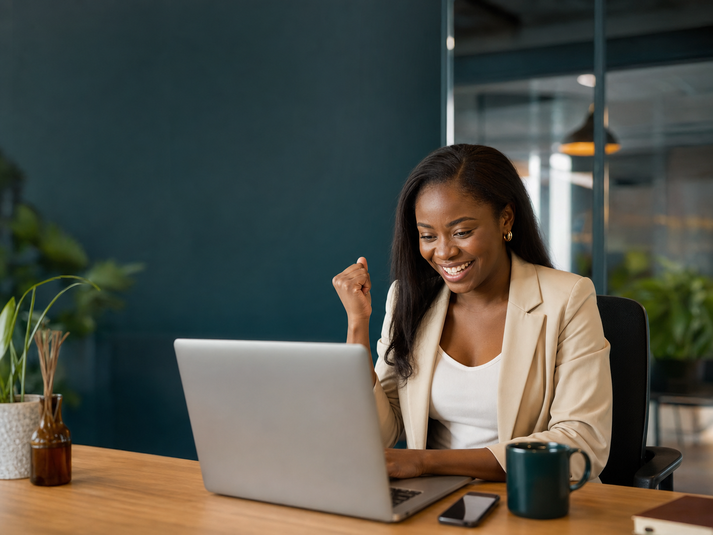 Professional celebrating a successful email and SMS delivery at her office desk